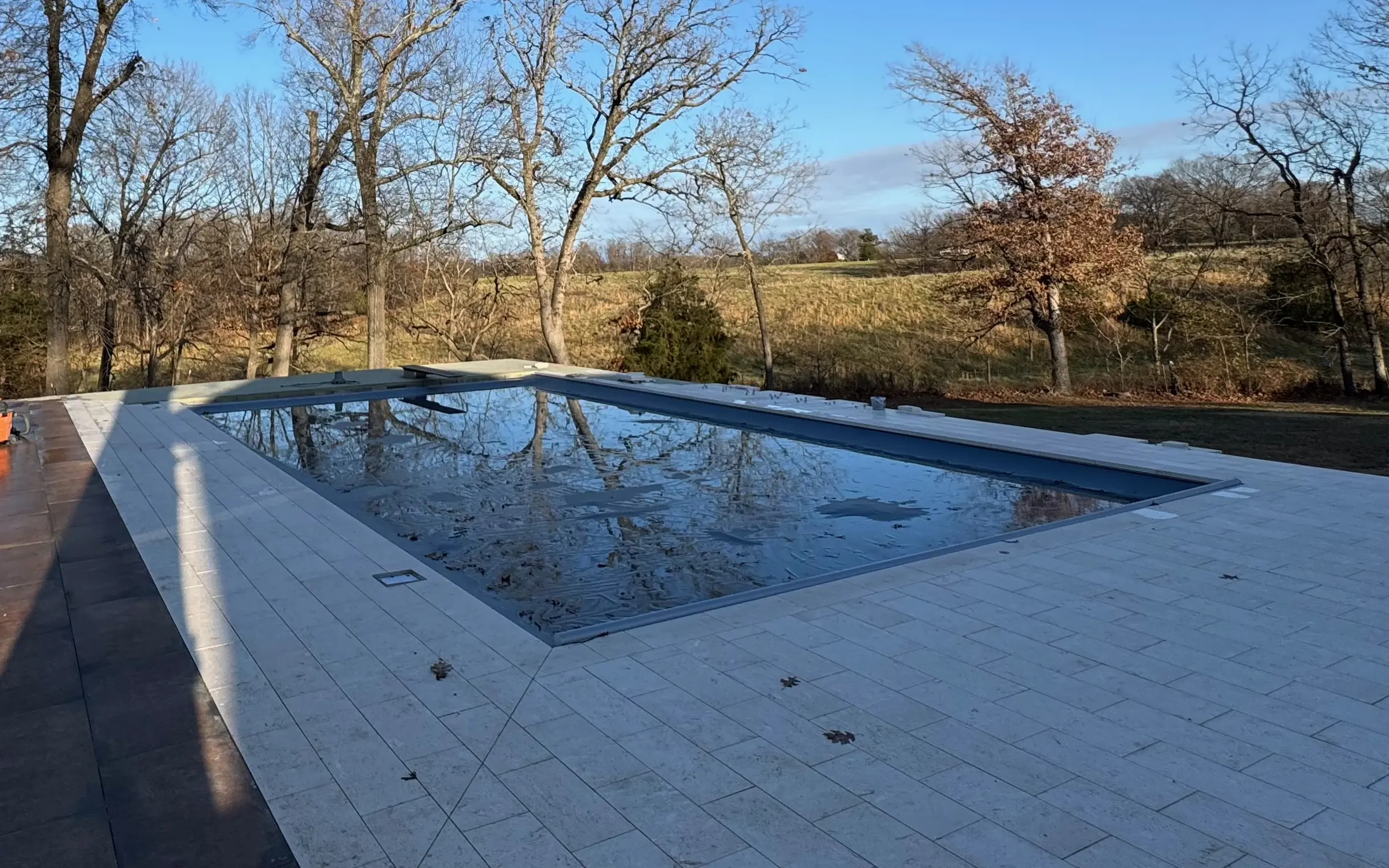 Pool with travertine deck and countryside view