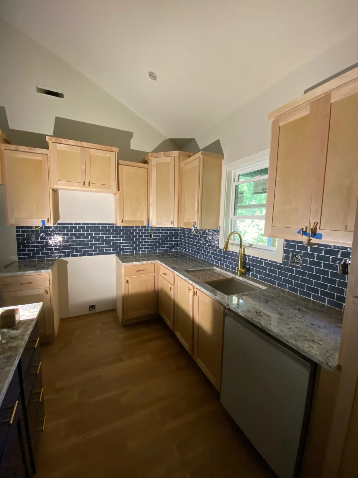 Kitchen with blue subway tile backsplash and granite counters