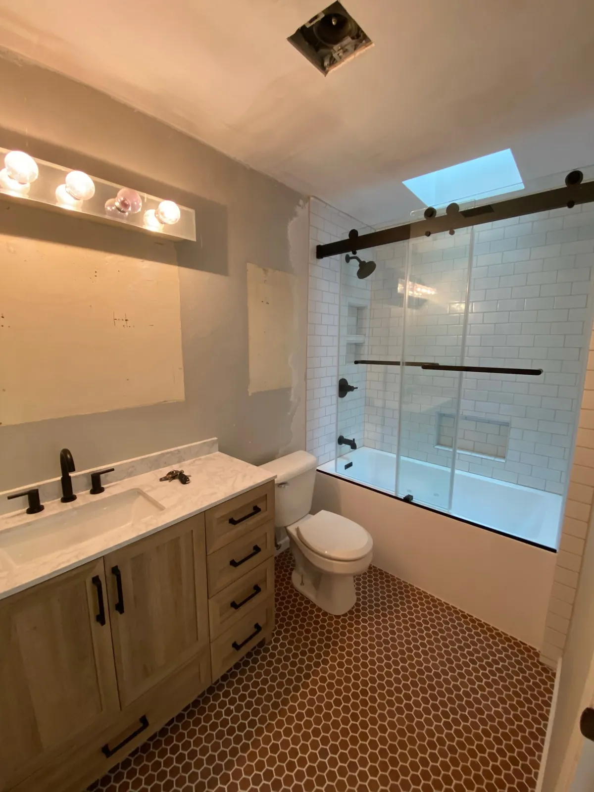 Bathroom with wood vanity and hexagon tile floor